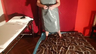 The strict Mistress in a rubber apron opens your butt