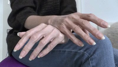 Long natural fingernails close-up on jeans legs